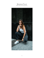 woman kneeling against dark granite wall fashion photography