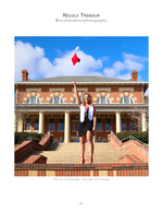 graduate tossing cap in front of brick campus building senior portrait photography