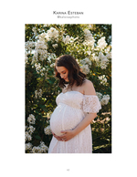 pregnant woman in lace gown among white blossoms maternity photography