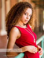 woman in red dress leaning on a railing senior portrait photography