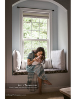 mother kissing newborn in a window seat newborn photography