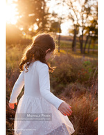 girl twirling through a golden autumn field portrait photography