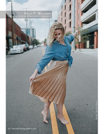 woman twirling a pleated skirt in the street fashion photography
