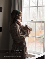 mother holding newborn baby at a window portrait photography