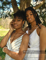 two women posed against a pine tree portrait photography