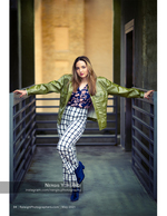 woman in a green leather jacket between metal gates fashion photography