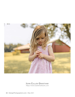 girl holding daisies in front of a red barn family photography