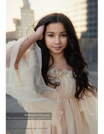 girl in flowing dress with city skyline behind her portrait photography
