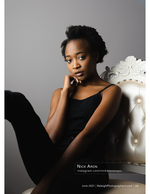 woman in black top posed in a studio armchair portrait photography