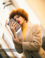 woman in a tan coat holding a leopard print clutch fashion photography