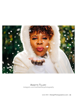 woman in a white fur-hooded coat blowing snow portrait photography