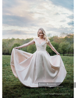 bride twirling her gown in an open field bridal photography