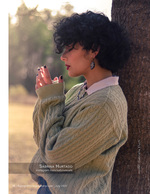 woman in a sweater leaning against a pine tree portrait photography