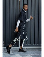 man in an avant-garde ribboned black and white outfit fashion photography