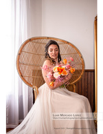 bride seated in a wicker peacock chair bridal photography