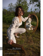 woman kneeling in a field with a round mirror reflection portrait photography
