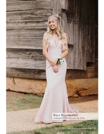 girl in a pink gown in front of a rustic barn senior photography