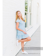 woman leaning against a white brick wall senior portrait photography