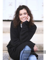curly-haired woman smiling on stone steps senior portrait photography