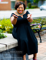 woman in a black dress reaching out on a stone ledge portrait photography
