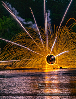 spinning steel wool light trails over water night photography