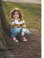 young boy crouched beside a tree trunk family photography