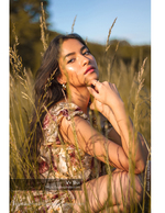 woman seated in a golden grass field portrait photography