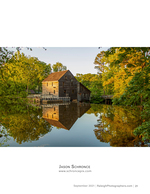 historic wooden grist mill reflected in a still pond landscape photography