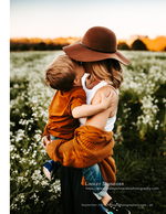 mother holding her son in a white flower field family photography