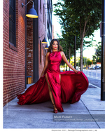 woman in a red satin gown on a city sidewalk fashion photography