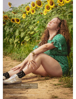 woman relaxing against a sunflower stalk portrait photography