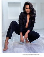 woman crouched in a black blazer and trousers fashion photography