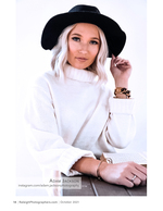 woman in a black wide-brim hat and ivory sweater studio portrait photography