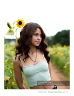 woman in a mint top standing in a sunflower field portrait photography