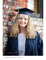 graduate in cap and gown against a brick wall portrait photography