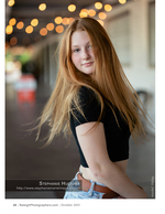 woman with red hair under string lights portrait photography