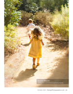 two children walking down a sunlit garden path family photography