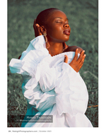 woman in a white ruffled blouse standing in a field portrait photography