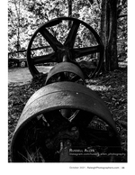 black and white photo of an antique iron wheel and roller nature photography