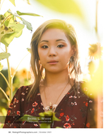 woman in a floral dress standing among sunflowers portrait photography