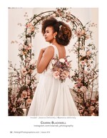 bride with a curly afro updo beneath a floral arch wedding photography