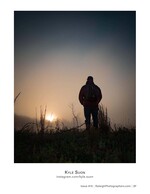 silhouette of a hiker watching the sunrise through fog portrait photography