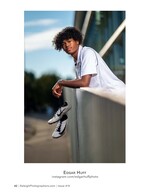 teen leaning on a railing holding his track cleats sports portrait photography