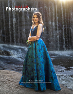 graduate in teal gown before a waterfall back cover photography