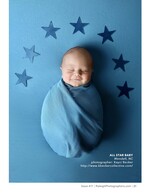 swaddled newborn surrounded by paper stars newborn portrait photography