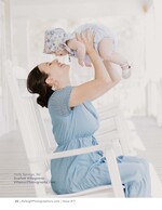 mother lifting laughing baby overhead on a porch baby portrait photography