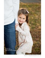 little girl clinging to her father's leg in a field children's portrait photography