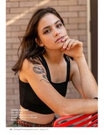 freckled model resting her chin on her hand against a brick wall fashion photography