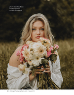 woman holding a flower bouquet in a golden field portrait photography