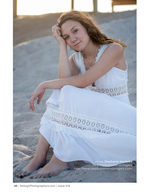 woman in a white lace dress seated on the beach portrait photography